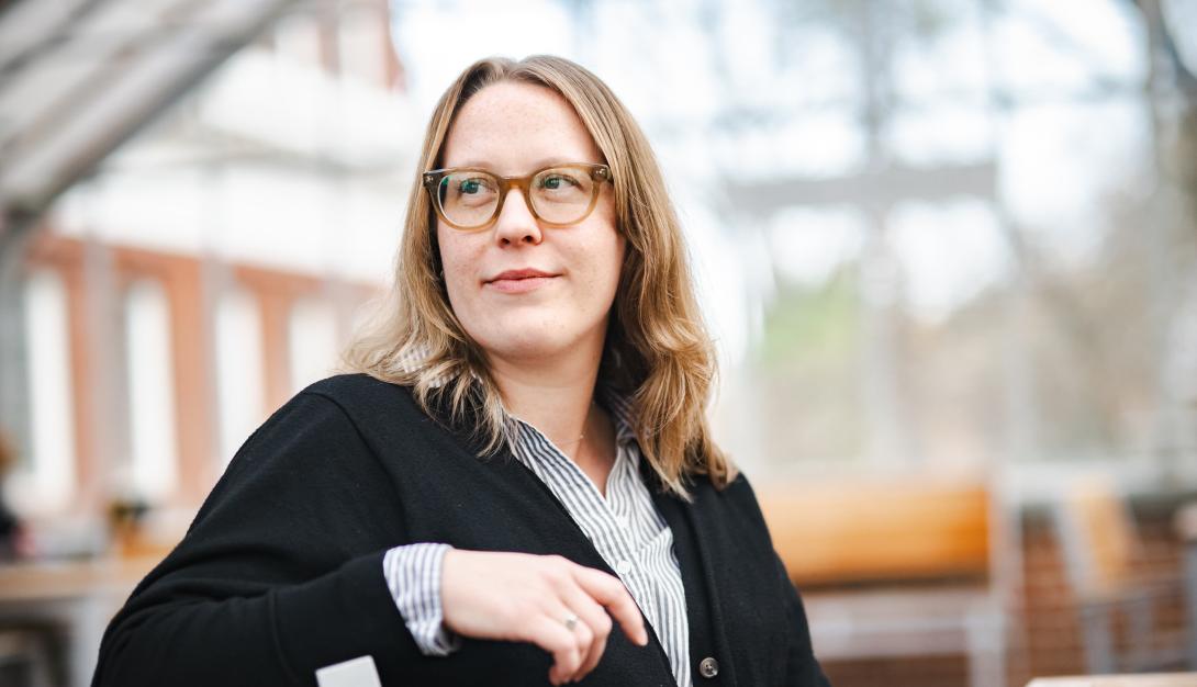 Amy Johnson sits on a chair and looks off to the side.